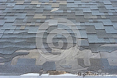 Ð¡lose up view of asphalt shingles roof damage that needs repair. Stock Photo